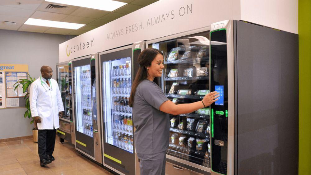 two people in front of a row of vending machines